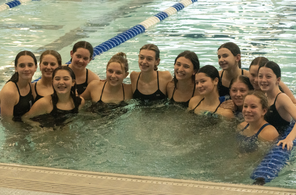 The girls of the swim team gather in the pool during a break to take a team photo. Coach Kampschmidt said, "Teamwork is an important part of swim and this photo shows that we have great teamwork." 